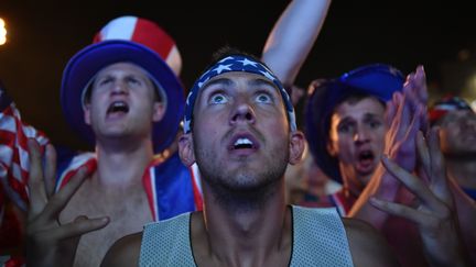 Des supporters de l'&eacute;quipe am&eacute;ricaine regardent le match contre le Portugal sur un &eacute;cran g&eacute;ant, le 22 juin 2014 &agrave; Rio (Br&eacute;sil). (YASUYOSHI CHIBA / AFP)