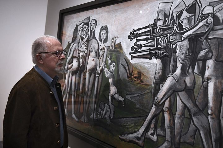 Fernando Botero regarde le tableau "Massacre en Corée" de Pablo Picasso, le 22 novembre 2017, exposé à l'Hôtel de Caumont, à Aix en Provence, dans le sud de la France, dans le cadre de l'exposition "Botero, dialogue avec Picasso". (BORIS HORVAT / AFP)