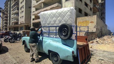 Un homme transportant un matelas à la Havane (22 mars 2021). (YAMIL LAGE / AFP)