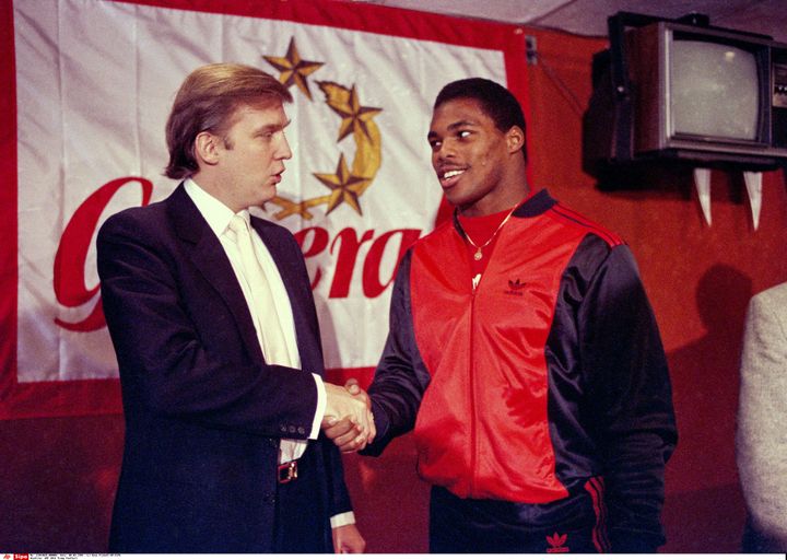 Donald Trump serre la main d'Herschel Walker, sa nouvelle recrue au sein des New Jersey Generals, le 8 mars 1984. (DAVE PICKOFF/AP/SIPA / AP)