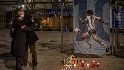 A Naples, deux personnes s'étreignent dans un hommage rendu à Diego Maradona, décédé le 25 novembre, à 60 ans (ALESSIO PADUANO / ANADOLU AGENCY)