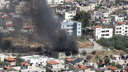 De la fumée s'échappe d'un immeuble à Jénine en Cisjordanie le 13 mai 2022. (JAAFAR ASHTIYEH / AFP)