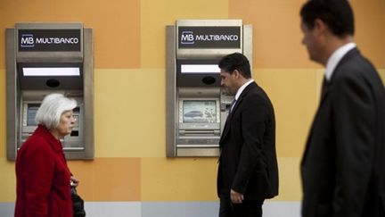 Des habitants de Lisbonne devant des distributeurs, le 7 avril 2011. (AFP PHOTO/PATRICIA DE MELO MOREIRA)