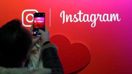 Une utilisatrice d'Instagram prend le logo en photo à Paris, le 7 février 2018. (CHARLES PLATIAU / REUTERS)