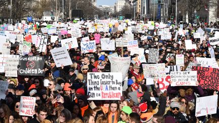 Des manifestants réclament un contrôle plus strict des armes à feu brandissent leurs pancartes, samedi 24 mars 2018 à Washington (Etats-Unis). (NICHOLAS KAMM / AFP)