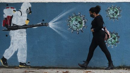 Une œuvre de street-art montrant une personne désinfectant un lieu pour lutter contre la propagation du coronavirus, le 15 juin 2020 à Rio de Janeiro (Brésil).&nbsp; (DIKRAN JUNIOR / AGIF)