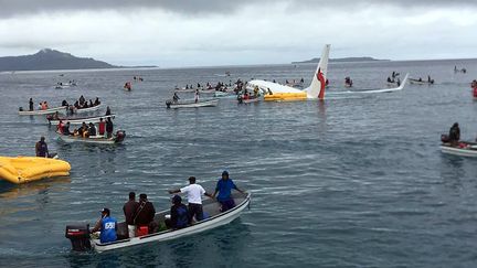 Cette photo de James Yaingeluo montre des habitants qui viennent en aide aux passagers de l'avion d'Air Niugini qui a amerri le 28 septembre 2018 près de l'île de Weno (Micronésie). (JAMES YAINGELUO / AFP)