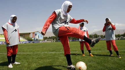 Les joueuses de l'&eacute;quipe nationale iranienne s'&eacute;chauffent avant un match amical contre le club de Malavan Anzali &agrave; T&eacute;h&eacute;ran (Iran), le 25 juin 2009. (AMIR POORMAND / AFP PHOTO)