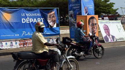 Le 3 mars 2016 à Cotonou: des motocyclistes passent devant les affiches des candidats Patrice Talon et Pascal Koupaki, candidats de la présidentielle béninoise dont le premier tour se tient le 6 mars 2016. (PIUS UTOMI EKPEI / AFP)