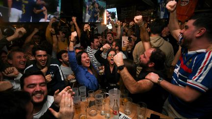 Dans un bar de Toulouse, des supporters français célèbrent la victoire de la France contre l'Angleterre en quart de finale de la Coupe du monde de football, le 10 décembre 2022. (VALENTINE CHAPUIS / AFP)