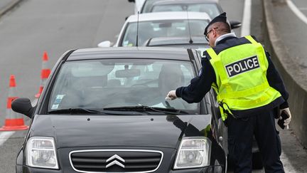 Un policier contrôle les attestations des automobilistes à Lille, le 3 avril 2020 (photo d'illustration). (DENIS CHARLET / AFP)