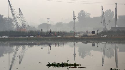 Des travailleurs sur le chantier de construction d'un pont sur la rivière Yaluna à New Delhi (Inde), le 30 novembre 2015. (ANINDITO MUKHERJEE / REUTERS)