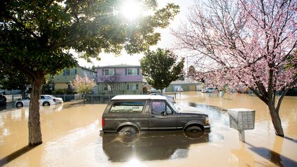 Une voiture repose dans les eaux de crue à San José, en Californie, le 22 février 2017. Des milliers de personnes ont dû évacuer leurs domiciles le mercredi précédent à cause des inondations.&nbsp; (NOAH BERGER / AFP)