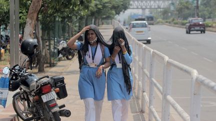 Des étudiantes se couvrent le visage pour se protéger du soleil, le 31 mars 2021 à Bhubaneswar (Inde). (NURPHOTO / AFP)