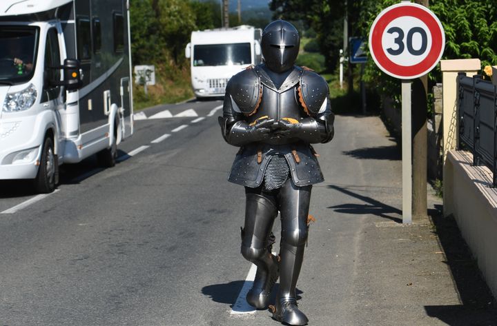 Abraham Poincheval marche le long d'un route à Carnoët (Côtes-d'Armor), dans son armure de 30 kilos, le 9 juillet 2018. Il est arrivé à Brest, le 16 juillet 2018, après dix jours de marche.&nbsp; (FRED TANNEAU / AFP)