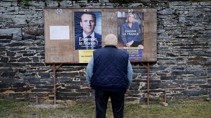 Un homme se tient devant les panneaux d'affichage électoraux, le 7 mai 2017, à&nbsp;Saint-Sulpice-des-Landes (Loire-Atlantique), à l'occasion du second tour de l'élection présidentielle. (JEAN-SEBASTIEN EVRARD / AFP)