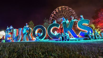 A Belfort, le 5 juillet 2019, des festivaliers s'installent sur les lettres géantes "Eurocks". (SEBASTIEN BOZON / AFP)