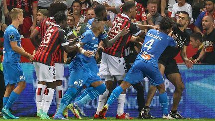 Des supporters niçois ont envahi le terrain et en sont venus aux mains avec les joueurs marseillais. (VALERY HACHE / AFP)