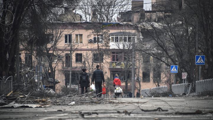 Des civils marchent dans le centre dévasté de Marioupol, le 12 avril 2022. (ALEXANDER NEMENOV / AFP)