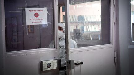 Une surveillante entre dans une zone confinée mise en place pour lutter contre le Covid-19 à la prison de Villepinte, jeudi 6 janvier 2022. (ALAIN JOCARD / POOL)