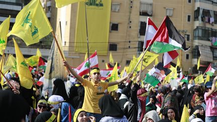 Un garçon brandit le drapeau du parti Hezbollah lors d'un rassemblement précédant un discours du chef du parti dans la banlieue sud de Beyrouth, le 3 novembre 2023. (AHMAD AL-RUBAYE / AFP)