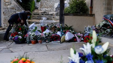 Une personne dépose des fleurs devant l'église de Saint-Léger-en-Yvelines (Yvelines), en hommage à Stéphanie Monfermé, le 29 avril 2021. (THOMAS SAMSON / AFP)