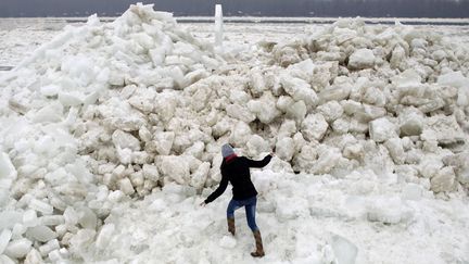 Une jeune femme escalade des blocs de neige sur le Danube &agrave; Belgrade (Serbie), le 20 f&eacute;vrier 2012. (MARKO DJURICA / REUTERS)