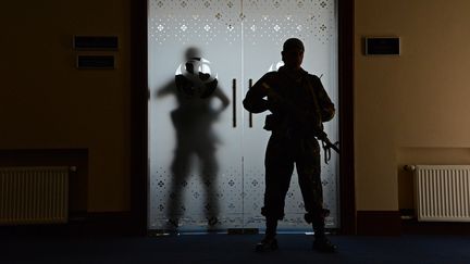 Des hommes en arme gardent l'entr&eacute;e de la salle dans laquelle le Premier ministre de la R&eacute;publique autoproclam&eacute;e de Donetsk, Aleksandr Borodai, donne une conf&eacute;rence de presse, samedi 17 mai 2014.&nbsp; (NATALIA SELIVERSTOVA / RIA NOVSTI)