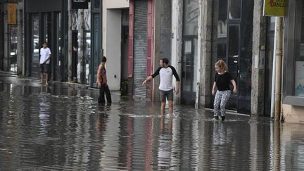 Des habitants de Lyon (Rhône) marchent dans les rues inondées après le passage d'un violent orage, mercredi 1er juillet 2020. (MAXPPP)