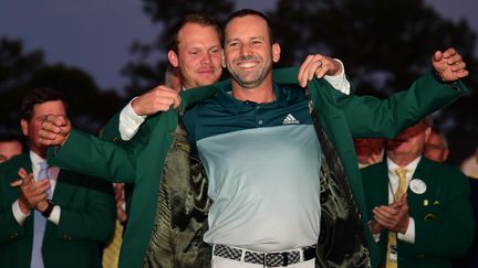 Sergio Garcia reçoit la veste verte, synonyme de victoire au Masters, des mains du vainqueur précédent : l'Anglais Danny Willett.  (HARRY HOW / GETTY IMAGES NORTH AMERICA)