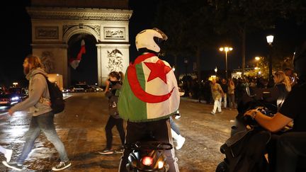 Des supporters de l'Algérie fêtent la victoire de l'Algérie en demi-finale de la Coupe d'Afrique des nations, le 14 juillet 2019, à Paris. (ZAKARIA ABDELKAFI / AFP)