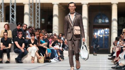 L'Afrique était au cœur de la collection Vuitton qui a emprunté aussi à l'esthétique punk londonienne. Avec un vestiaire aux tons beige, chocolat, kaki, le Britannique Kim Jones, a évoqué le continent de son enfance passée au Kenya et au Botswana. Chaussé de sandales de sport, le voyageur porte une chemise en soie à motifs ou une veste saharienne. Des têtes grimaçantes de rhinocéros ou de girafes s'impriment sur les vêtements et les sacs, fruits d'une collaboration avec les frères et artistes britanniques Jake et Dinos Chapman.
 (Thibault Camus/AP/SIPA)