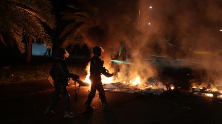 Des gendarmes interviennent sur un barrage dans un quartier du Gosier en Guadeloupe le 20 novembre 2021. (PHILIPPE DE POULPIQUET / MAXPPP)