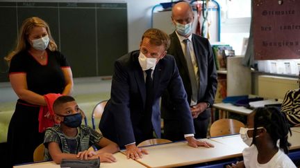 Emmanuel Macron, accompagné du ministre de l'Education Jean-Michel Blanquer, en visite dans une école à Marseille le 2 septembre 2021. (DANIEL COLE / POOL)