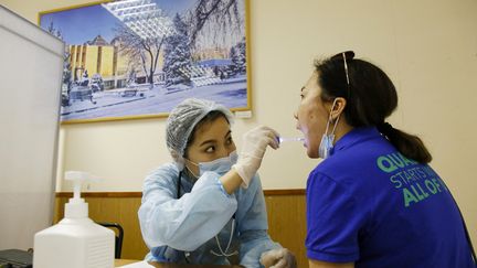 Une femme&nbsp;passe un examen médical avant de recevoir une dose du vaccin russe Spoutnik V à Almaty, au Kazakhstan, le 17 avril 2021, avant l'arrivée du vaccin local&nbsp;Qazvac, distribué à partir du 26 avril.&nbsp;Photo d'illustration. (RUSLAN PRYANIKOV / AFP)