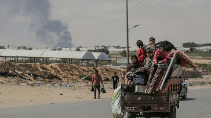 Palestinians flee Rafah aboard a cart, May 29, 2024. (BASHAR TALEB / AFP)