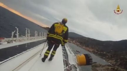 Un pompier italien inspecte l'&eacute;pave du "Costa Concordia" &agrave; la recherche de survivants, le 16 janvier 2012. (FTVi / APTN)