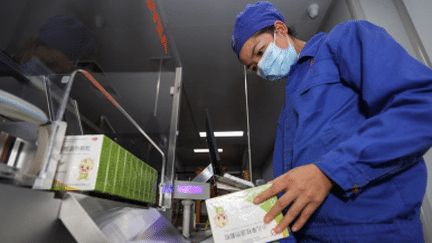 Un salarié vérifie une boîte de médicaments contre la fièvre, le 24 décembre 2022, dans une usine à Anshun (Chine). (AFP)