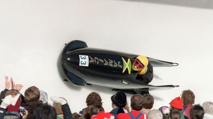 Emmené par le pilote Dudley Stokes, le bobsleigh jamaïcain dévale la piste olympique de Calgary (Canada),&nbsp;le 20 février 1988.&nbsp; (MARC CARDWELL / AFP)