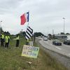 Des "gilets jaunes" du camp d'Atlantheix, près de Vannes (Morbihan), répondent aux coups de klaxon des automobilistes, le 16 mai 2019. (LOUIS BOY / FRANCEINFO)