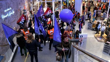 Des manifestantes, dans un magasin de vêtements de Madrid, le 8 mars 2018, appellent à la grève des femmes en Espagne. (OSCAR DEL POZO / AFP)