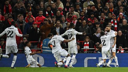 Les Madrilènes célèbrent le but de Karim Benzema lors du huitième de finale aller de Ligue des champions entre Liverpool et le Real Madrid à Anfield, le 21 février 2023. (PAUL ELLIS / AFP)