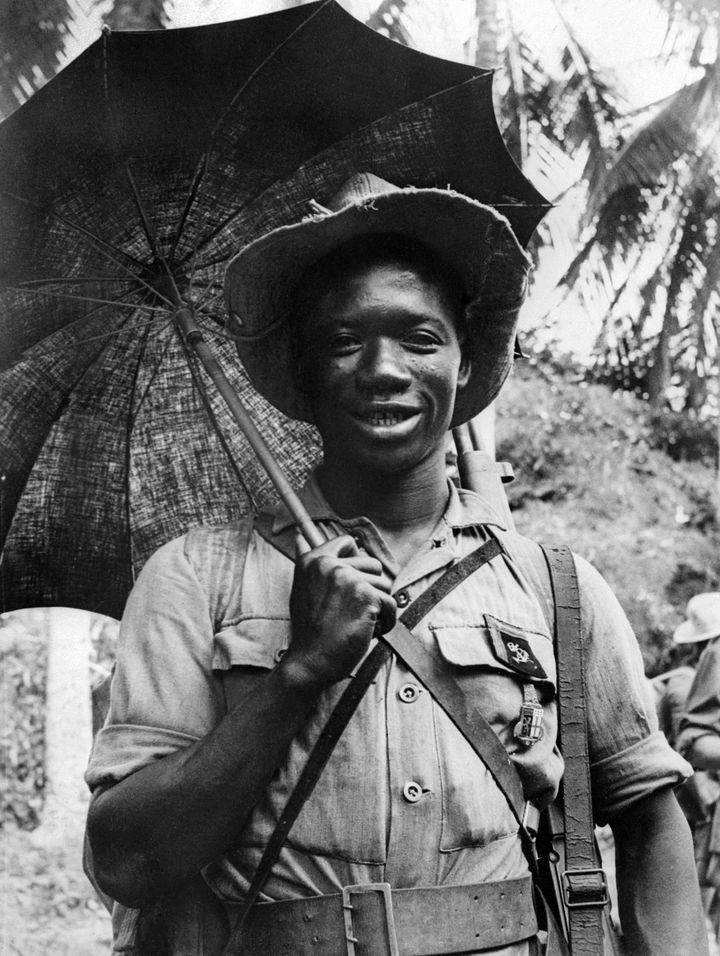 Un soldat d'origine guinéenne, combattant en Indochine dans les rangs de l'armée française, pose avec une ombrelle le 20 juillet 1952.&nbsp; (AFP - INTERCONTINENTALE)