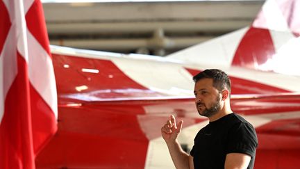 Le président ukrainien Volodymyr Zelenski devant l'un des F-16 que le Danemark lui a promis, le 23 août 2023 à Vojens. (SERGEI GAPON / AFP)