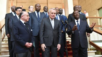 Le président ivoirien, Alassane Ouattara (D), reçoit à Abidjan les ministres français des Affaires étrangères, Jean-Marc Ayrault (C), et de l'Intérieur, Bernard Cazeneuve (G), le&nbsp;15 mars 2016.&nbsp; (SIA-KAMBOU / AFP)