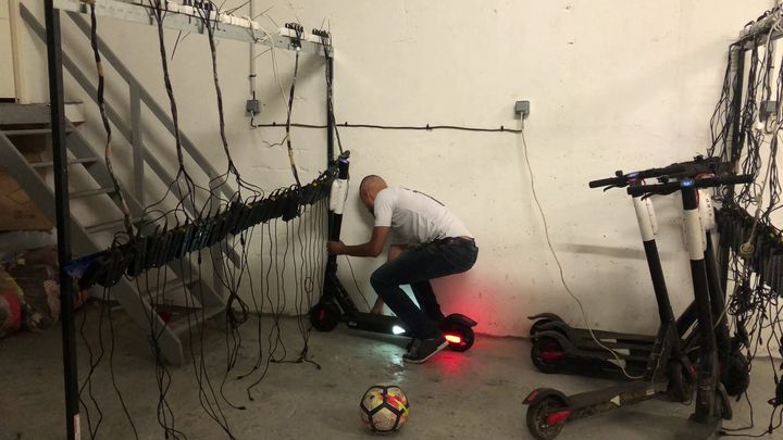 Grâce à l'installation qu'il a mise en place dans son local, Imad recharge les trottinettes électriques qu'il a glanées. (CAMILLE ADAOUST / FRANCEINFO)