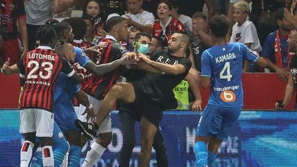 Profitant&nbsp;d'un envahissement de terrain, un supporter niçois a agressé Dimitri Payet lors de Nice-OM, le 22 août 2021. (VALERY HACHE / AFP)