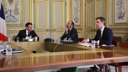 Emmanuel Macron, Edouard Philippe et Olivier Véran lors d'une réunion à l'Elysée le 24 mars 2020 (LUDOVIC MARIN / POOL)