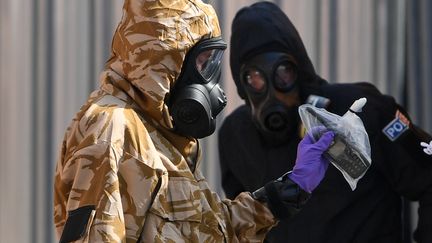 Un enquêteur en combinaison de protection,&nbsp;à Amesbury (Royaume-Uni), le 6 juillet 2018, pendant l'enquête sur l'empoisonnement au Novitchok de plusieurs Britanniques. (CHRIS J RATCLIFFE / AFP)