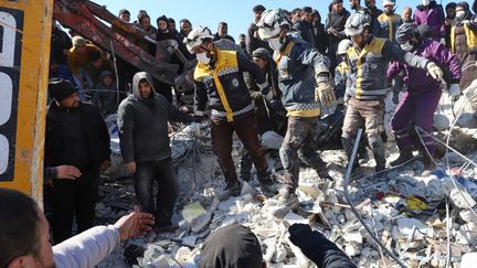 Des casques blancs dans les décombres d'immeubles à Azmarin, dans la province d'Idlib, en Syrie, le 8 février 2023. (ABDULAZIZ KETAZ / AFP)